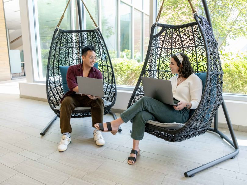 Capital One teams discuss a project together while sitting in chairs in the office