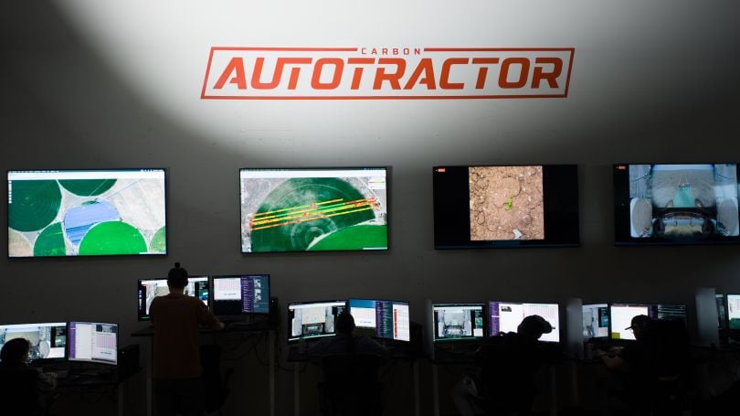 Interior image of trained remote tractor operators in the Carbon AutoTractor remote operations control center