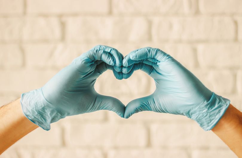 Close up of hands wearing medical gloved making a heart shape