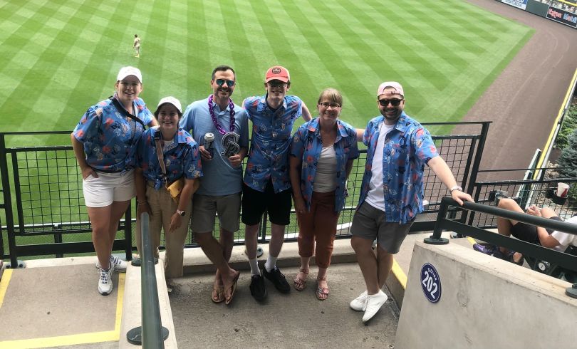 DAS42 team members in matching Hawaiian shirts at a baseball game