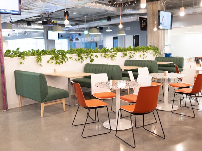 CDM office cafeteria with tables and colored chairs