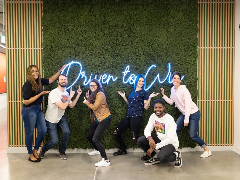 team photo in front of neon light sign