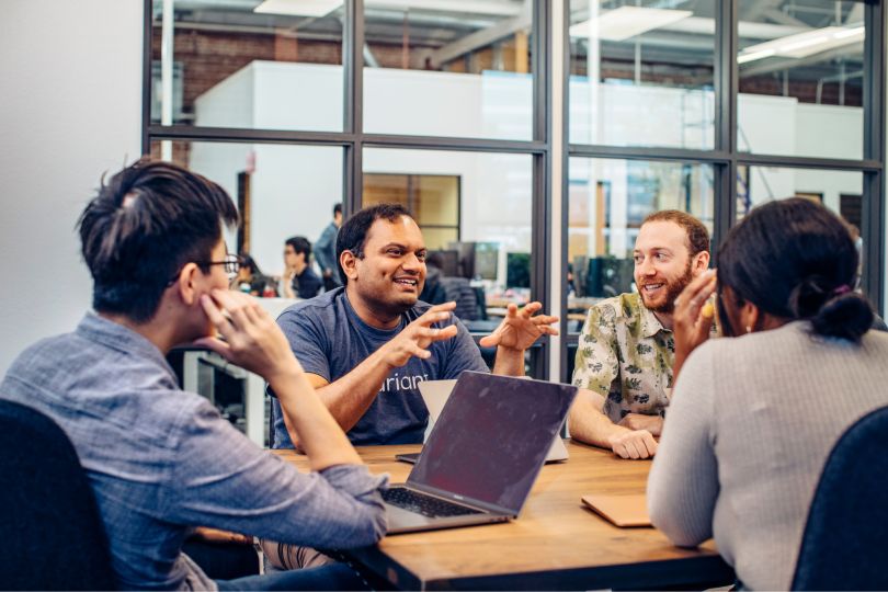 A group of Covariant employees enthusiastically discussing a project.