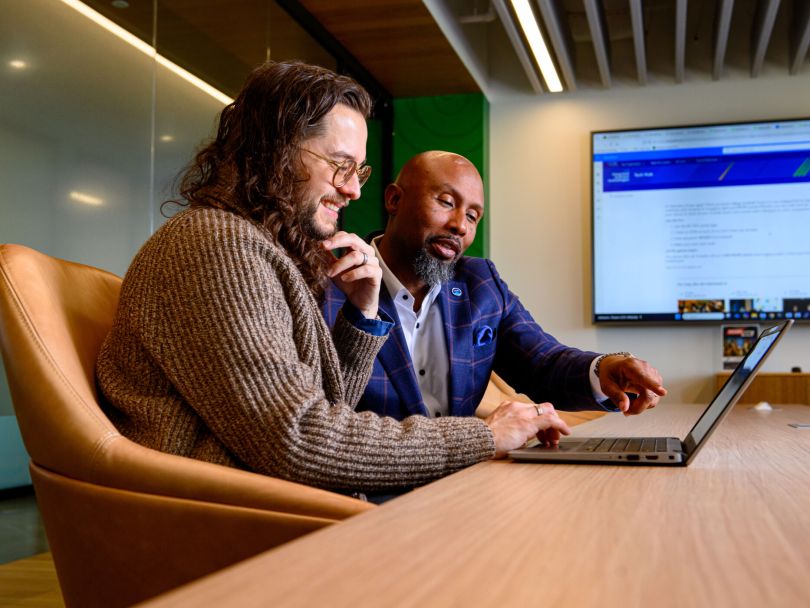 Two Cox Enterprises team members work on a project together in the company's office