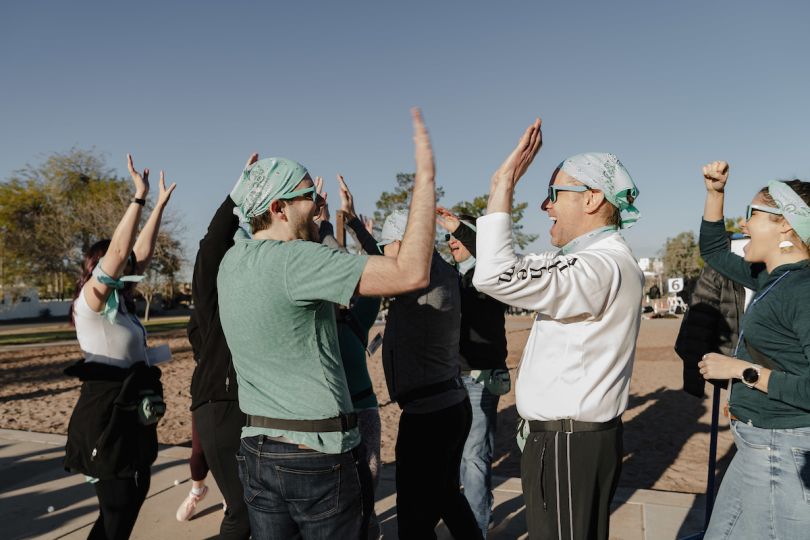 Group celebrating, high-fiving outside
