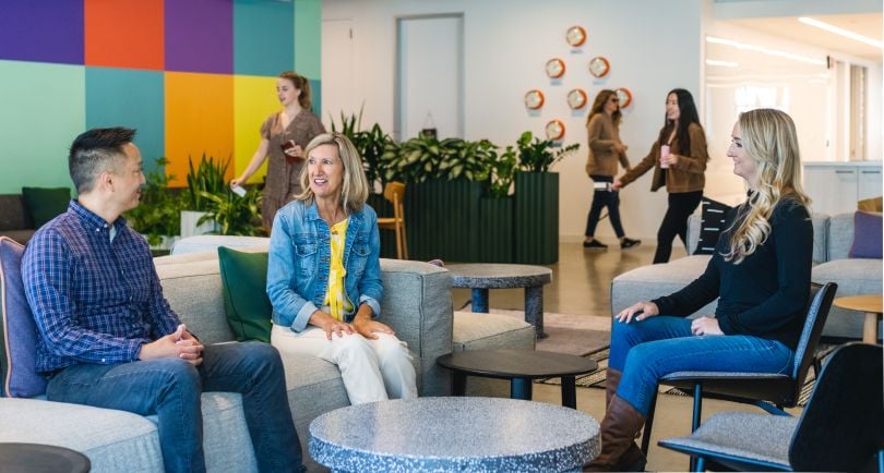 Three Udemy team members sitting on couches in conversation