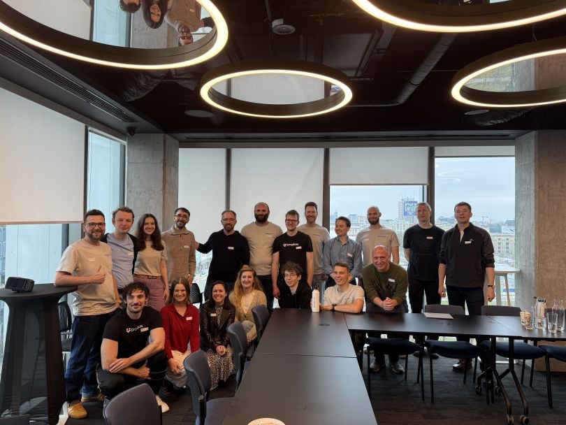 A large group of Dropbox employees pose for a group photo in a conference room