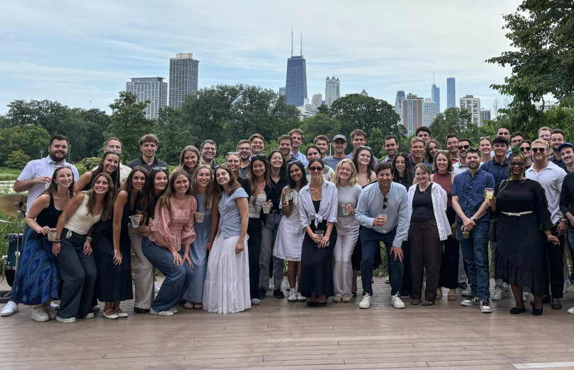 Energy CX team members pose for a large group in a park with the Chicago skyline in the background