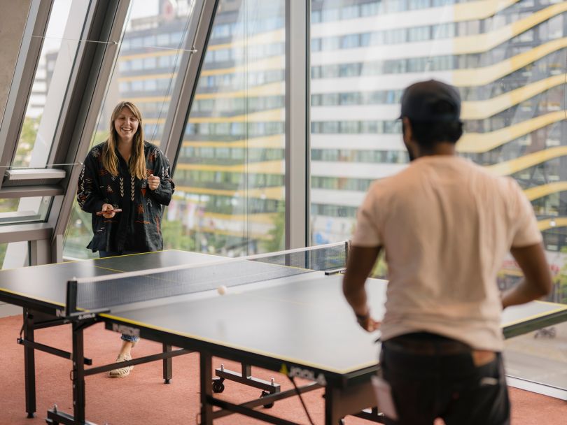 Grammarly team members playing a game of ping pong in the office