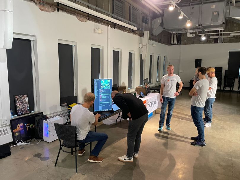 Tech team members gather around a table at a work event.&nbsp;