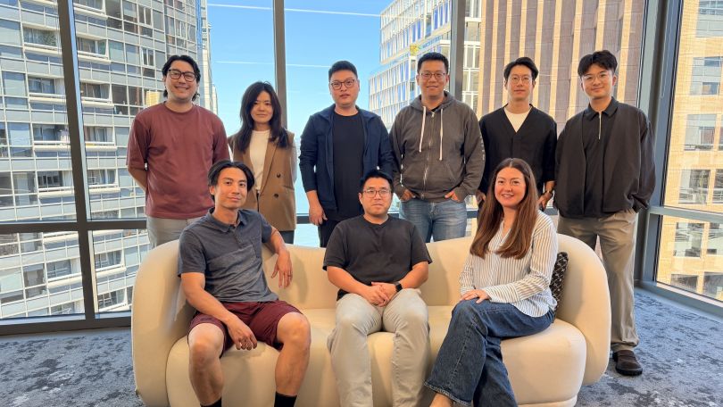 Airwallex team sitting together for a photo in front of a window. 