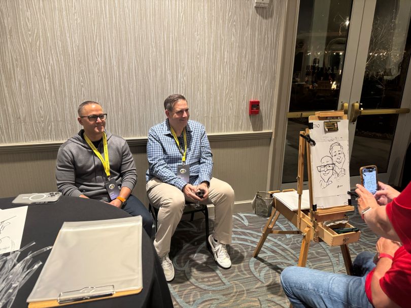 Two Kustomer team members pose for caricature drawings