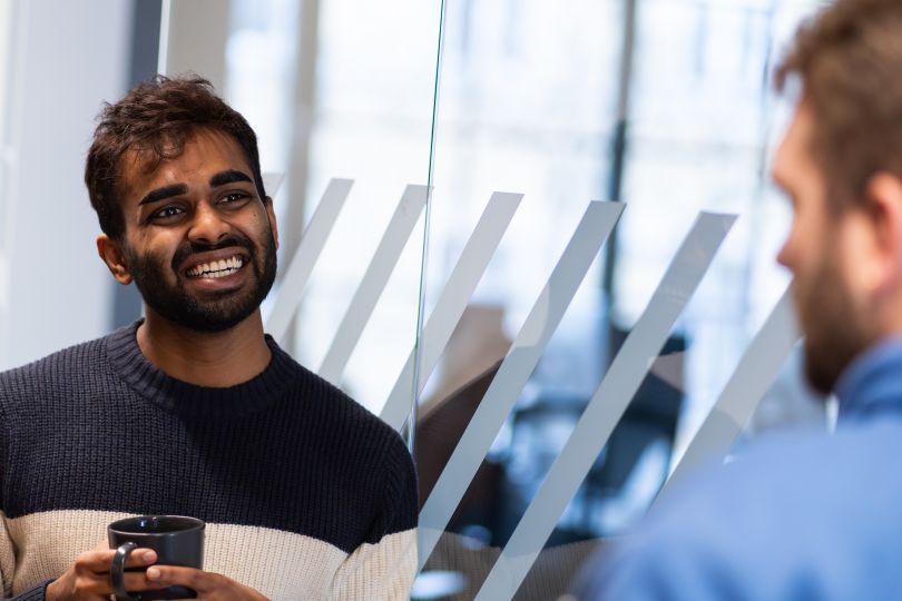 Two Rapid7 team members chat in one of their global offices.