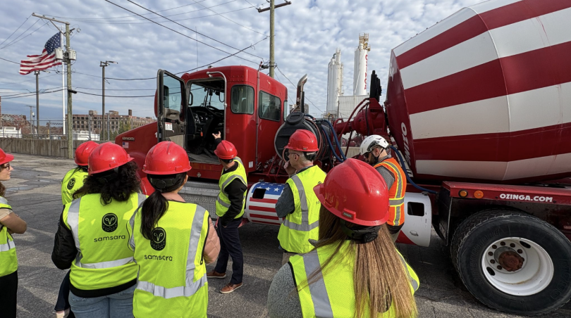 Samsara team members wearing construction attire while standing next to a truck