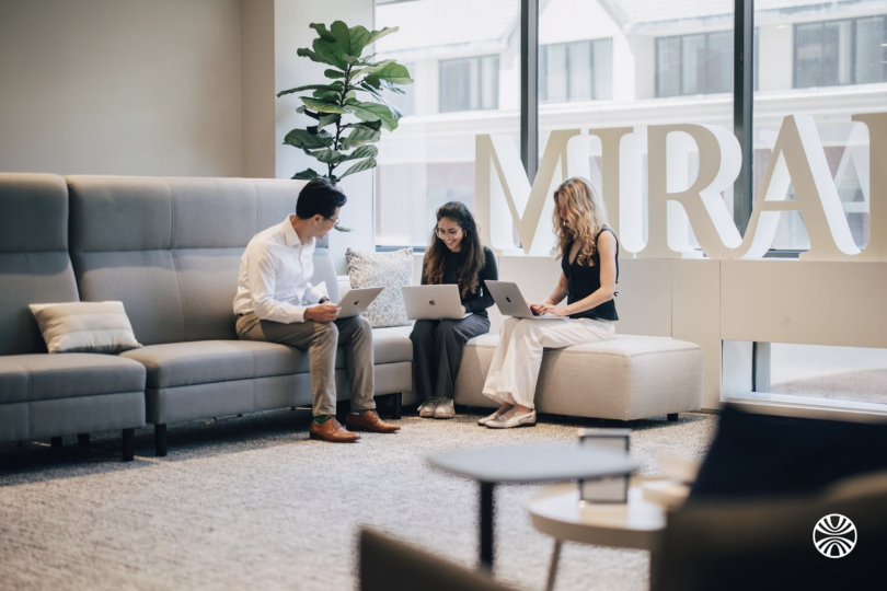 Three Mirakl team members discuss a project together in the office
