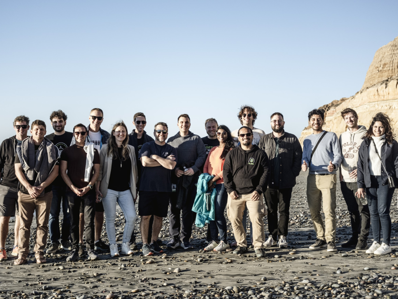 ServiceNow team members posing for a group photo on a beach