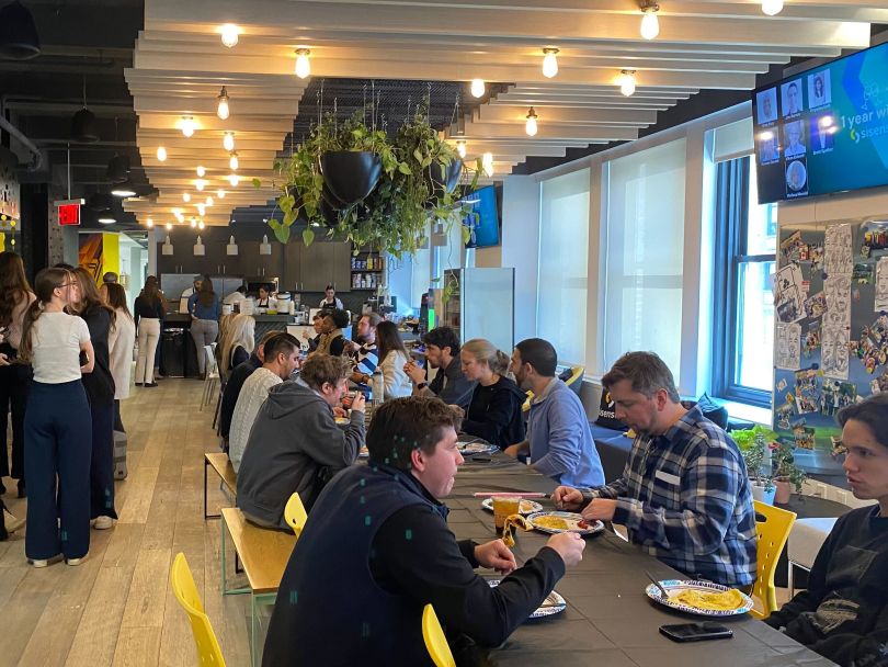 Sisense team members eat lunch together at tables in the office