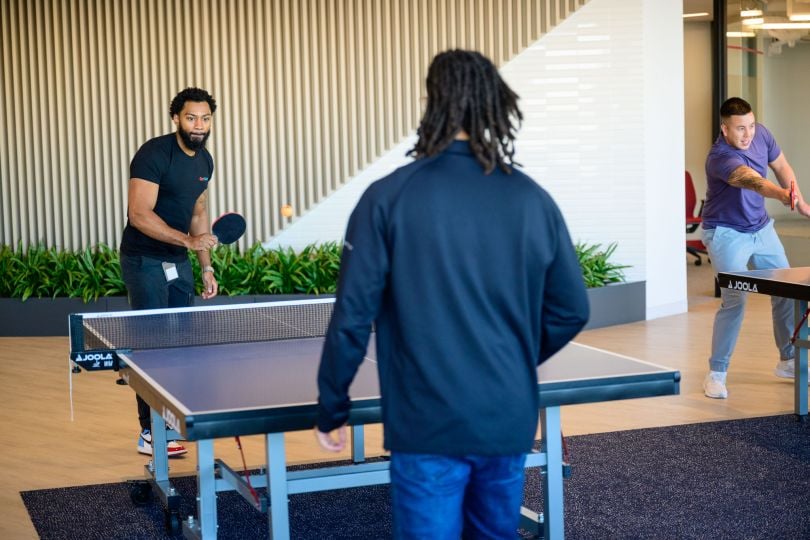 CarGurus employees playing table tennis in the company’s new global headquarters inside Boston’s new Lyrik Back Bay project at 1001 Boylston Street.&nbsp;