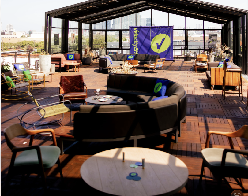 An outdoor space decorated with VelocityEHS-branded items during a company event.