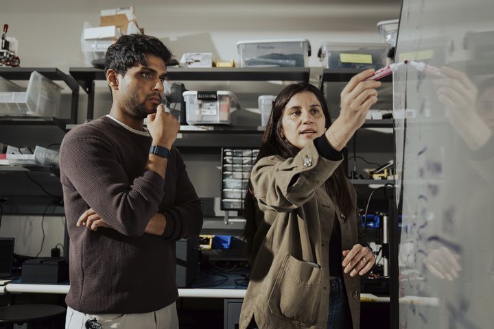 Two WHOOP employees brainstorm ideas on a whiteboard in the company’s Boston office