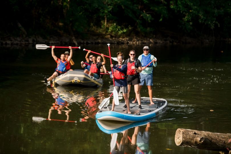 AWeber team members river raft and paddle board at a company retreat.&nbsp;
