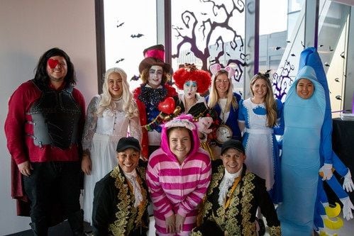 Group photo of people in costumes at IEX’s Friends & Family Fest.&nbsp;