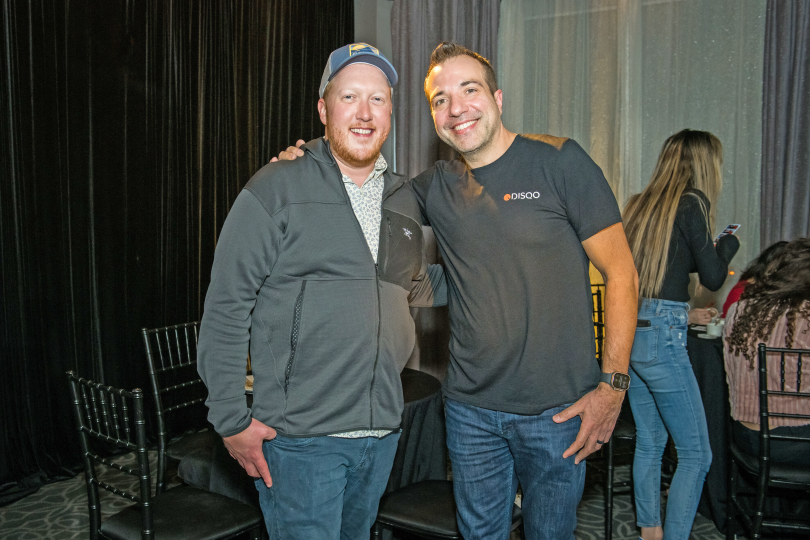 Tim Shea stands with a colleague at an indoor event.&nbsp;