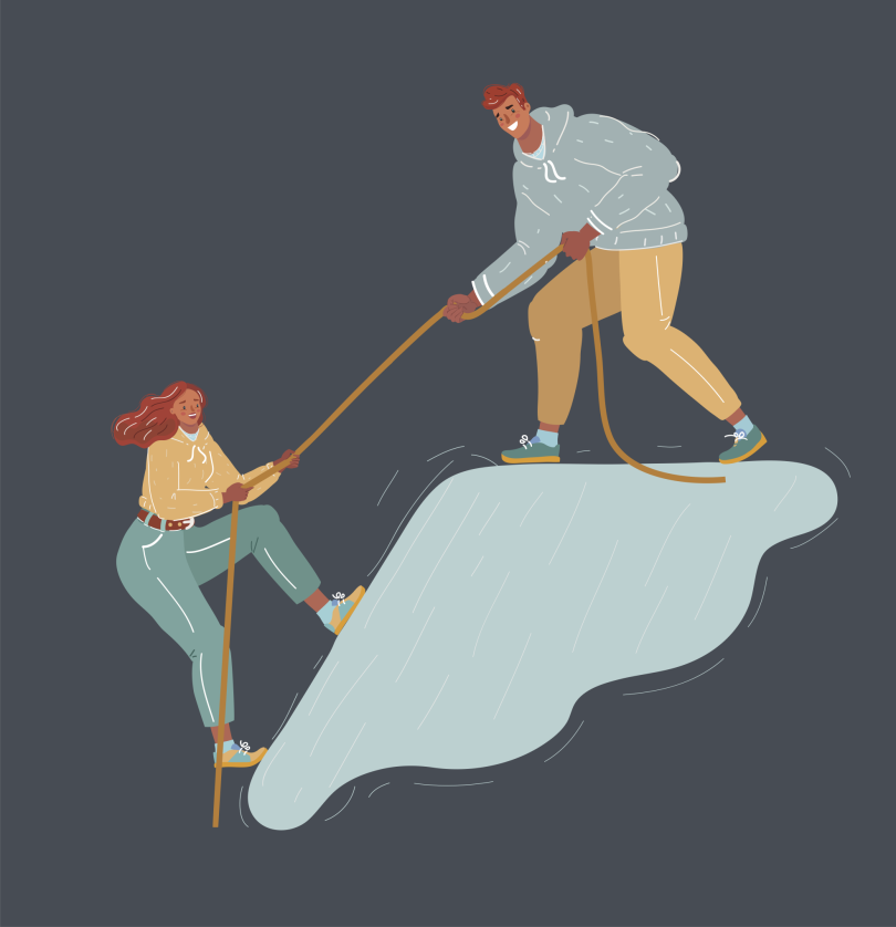 A coworker helping a fellow coworker up a hill.