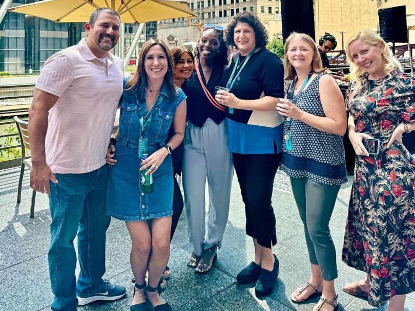 Six HERE Technologies team members pose for a group photo while attending a summer party on a patio in Chicago