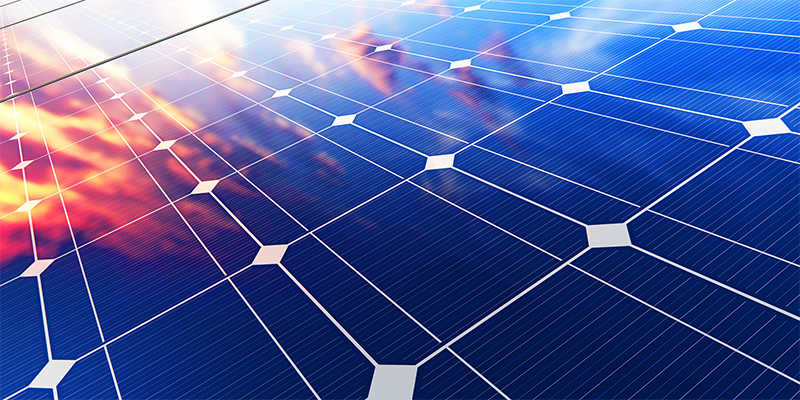 A close up angle of a solar panel with the sun reflecting off of its surface.