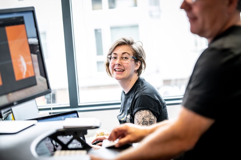 Tango Card employees chat at their workstations.