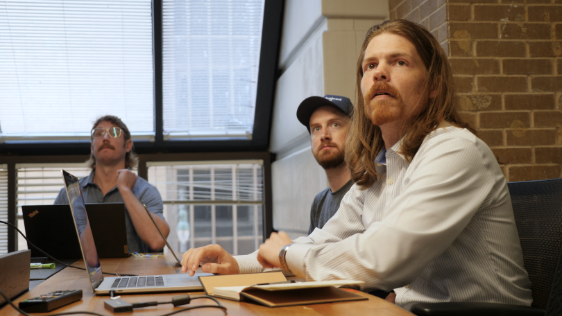 Unchained team members watching presentation together in the office.&nbsp;