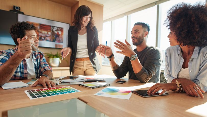 A marketing team discusses something at a table.