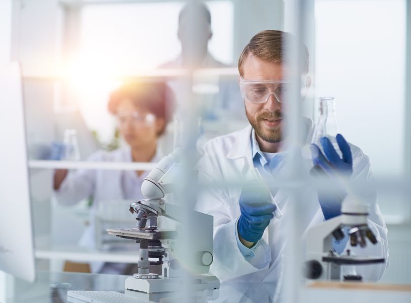 A medical researcher works with a microscope.