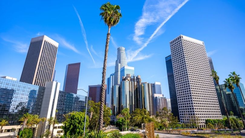 Several buildings stand against the Los Angeles skyline.