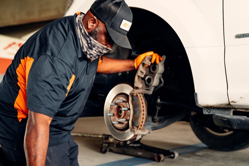A NuBrakes mechanic works on a car