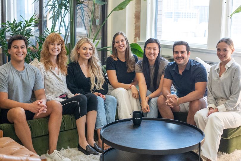 Relevize team members sit together on a green couch