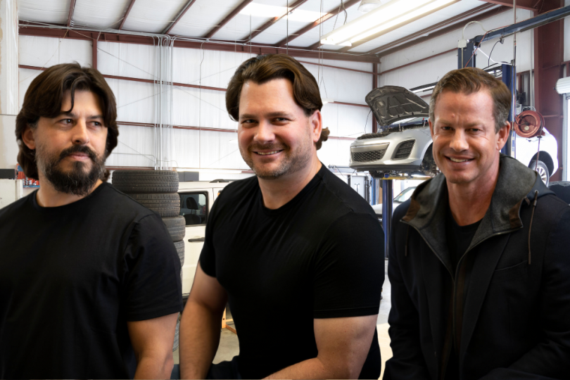 ServiceUp co-founders in front of an automobile repair shop floor