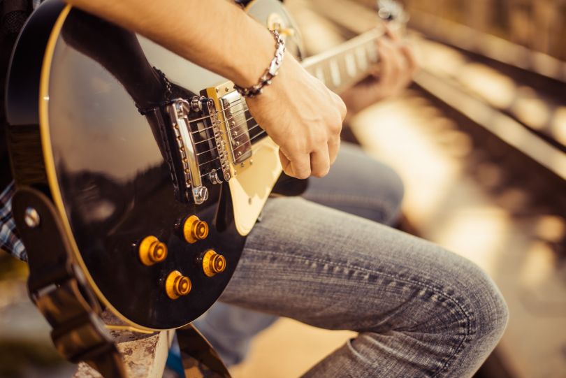 A person is shown playing a guitar.