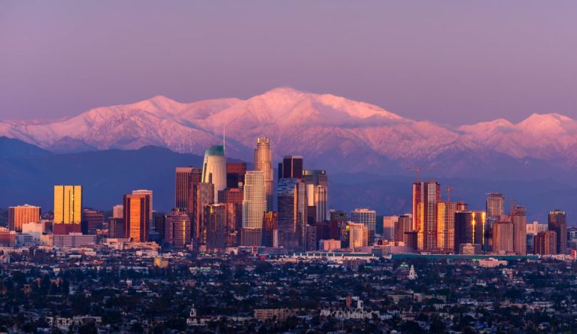 The Denver skyline with the Rocky Mountain in the background.