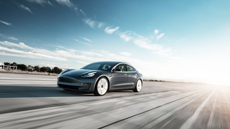 a car is pictured speeding down a road.
