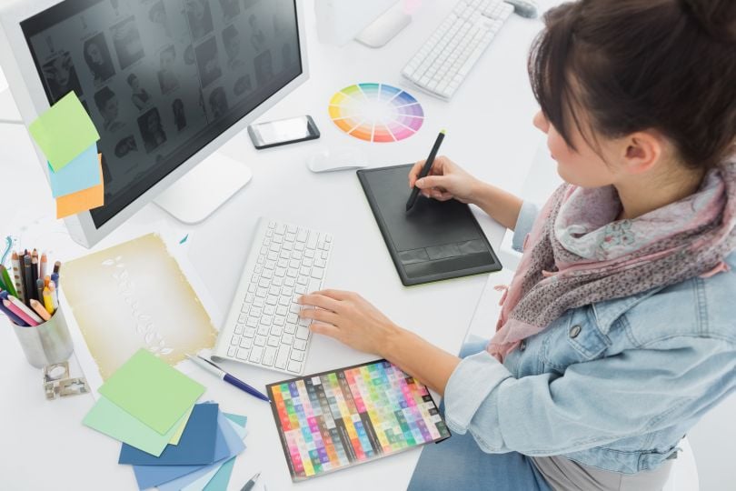 artist working on computer with color palettes 
