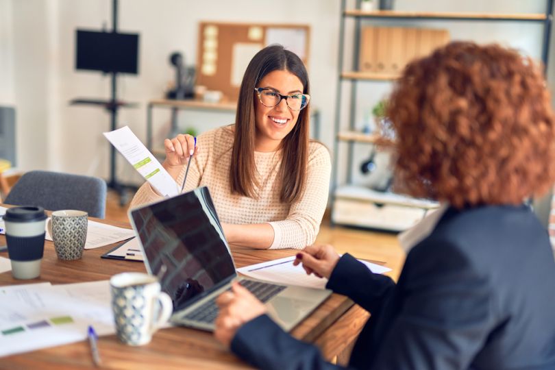 A group of coworkers meet around a conference table