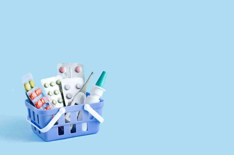 Medications are pictured sitting in a small blue basket.
