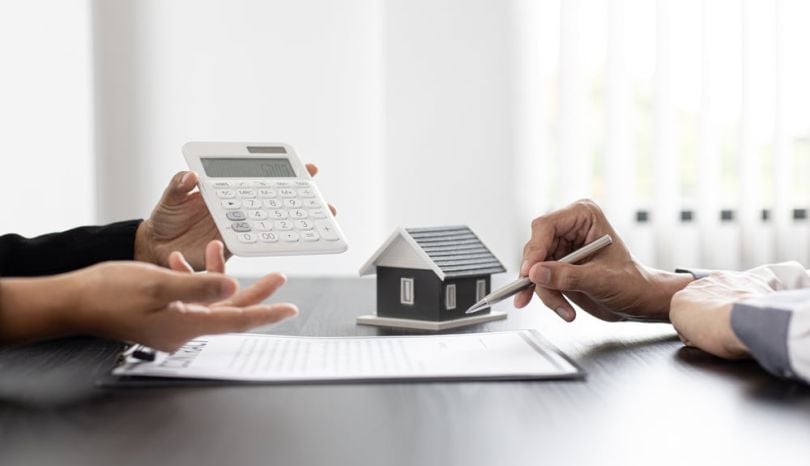 A real estate agent and homebuyer look over a contract.
