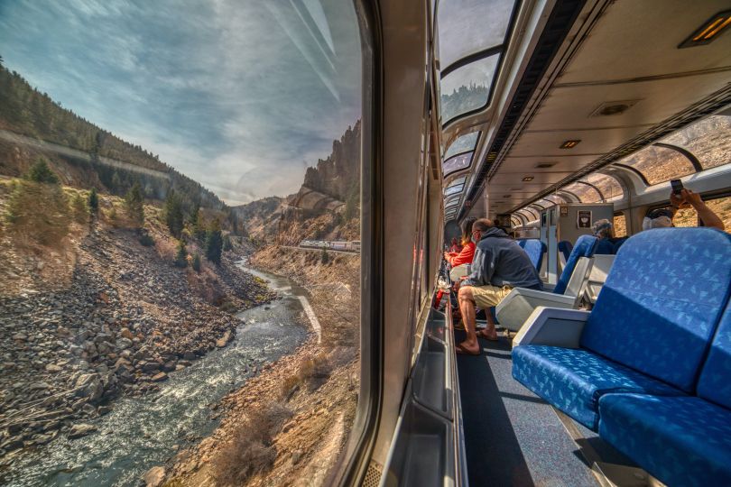 An Amtrak train riding through the Rocky Mountains into Denver, Colorado