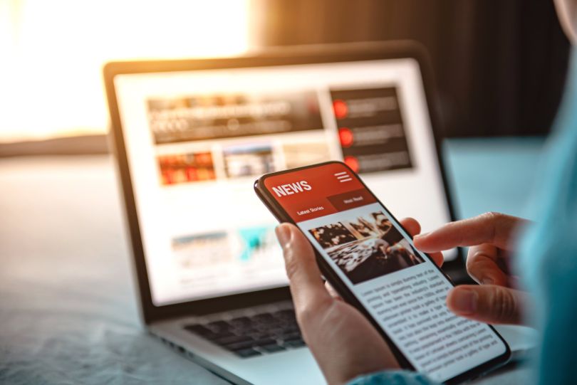 A person scrolls through news on their smartphone