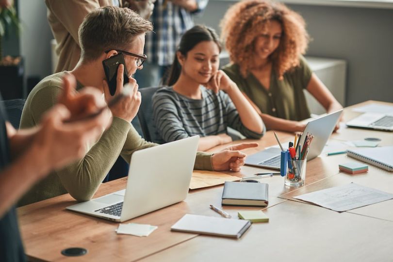 Men and women working together while on the phone 