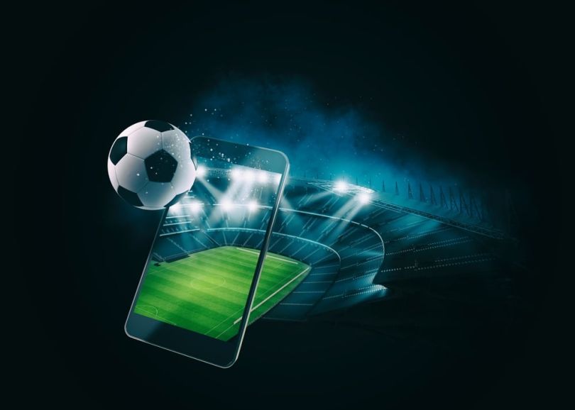 A soccer ball launches out of a phone screen.&nbsp;