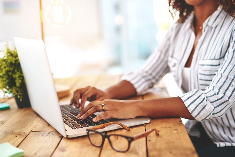 A close up of a woman typing on a computer